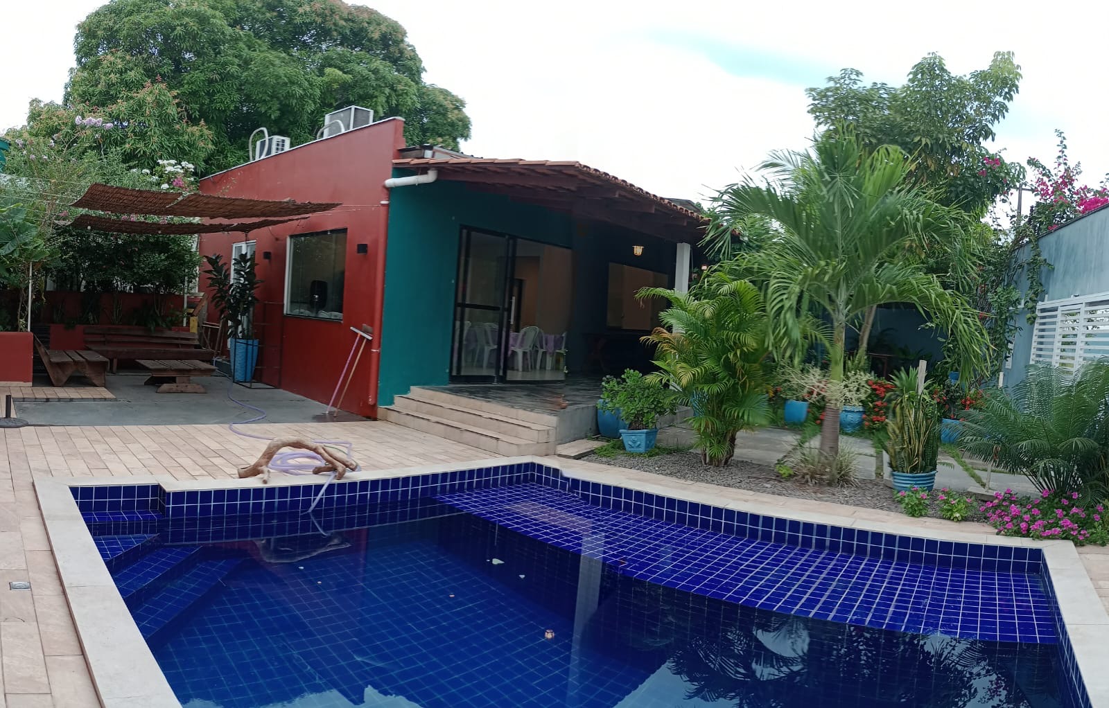 Piscina, jardim e varanda da Casa Bella Eventos durante o dia