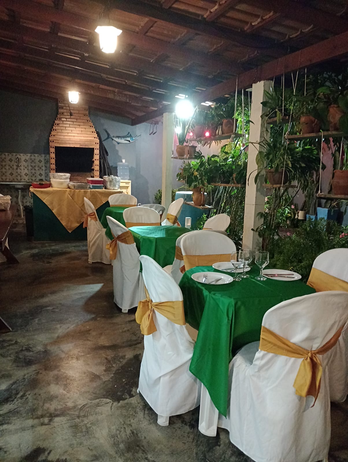 Varanda coberta com mesas e churrasqueira externa